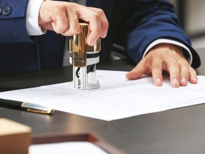 mężczyzna przybijający pieczęć na dokumentach