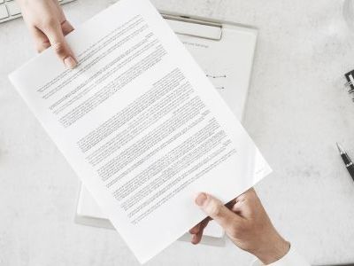 pracownicy przekazujący sobie dokumenty